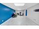 Spacious partially-finished basement has bright lighting, gray floors, and a blue accent wall at 4817 Overland Dr, Powder Springs, GA 30127