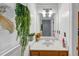 Bathroom featuring decorative accents, a wood vanity, and an elegant mirror with decorative lighting fixture at 4817 Overland Dr, Powder Springs, GA 30127