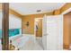 Bright bathroom features a jacuzzi tub, a large window, and an entrance to another room at 4817 Overland Dr, Powder Springs, GA 30127