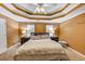 Spacious bedroom features a unique tray ceiling, a ceiling fan, bedside tables and lamps, and plush carpeting at 4817 Overland Dr, Powder Springs, GA 30127