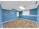 Carpeted bedroom with blue walls features a window and bright lighting at 4817 Overland Dr, Powder Springs, GA 30127