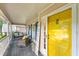 Inviting covered front porch with comfortable seating and a vibrant yellow door with modern decor at 4817 Overland Dr, Powder Springs, GA 30127