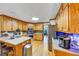 Spacious kitchen with wood cabinets, stainless steel appliances, and tile backsplash with view into breakfast nook at 4817 Overland Dr, Powder Springs, GA 30127