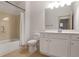 Well-lit bathroom features a shower-tub combo and white vanity with ample storage at 1585 Oak Meadows Ln, Cumming, GA 30041