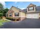 Two-story home featuring a two-car garage, lush landscaping, and classic brick and siding exterior at 1585 Oak Meadows Ln, Cumming, GA 30041