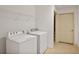 Bright laundry area includes a white washer and dryer set, plus shelving for storage at 1585 Oak Meadows Ln, Cumming, GA 30041