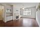 Spacious living room featuring hardwood floors, a fireplace, built-in cabinets, and a large window at 1585 Oak Meadows Ln, Cumming, GA 30041