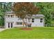 Charming home featuring a grey brick facade, well-manicured lawn, and a beautiful tree in the front yard at 3034 Barksdale Cir, Atlanta, GA 30344