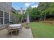 Private backyard featuring a patio with dining set, lush landscaping, and play area at 4218 Sandy Branch Dr, Buford, GA 30519