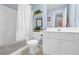 Bright bathroom featuring a shower-tub combo, white vanity and blue wall paint at 4218 Sandy Branch Dr, Buford, GA 30519