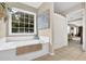 Relaxing bathroom featuring a large soaking tub and window overlooking backyard at 4218 Sandy Branch Dr, Buford, GA 30519