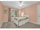 This bedroom includes a four-poster bed, neutral carpet, a ceiling fan, and an exterior window at 4218 Sandy Branch Dr, Buford, GA 30519