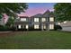 Charming two-story home with a well-kept lawn, surrounded by lush trees and illuminated by the setting sun at 4218 Sandy Branch Dr, Buford, GA 30519