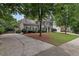 Traditional-style home with a well-maintained lawn, mature trees, and a driveway at 4218 Sandy Branch Dr, Buford, GA 30519