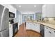 Bright kitchen with white cabinets, stainless steel appliances, and hardwood floors at 4218 Sandy Branch Dr, Buford, GA 30519