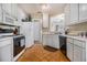 Bright kitchen featuring white cabinetry, modern appliances, and parquet flooring at 7008 Glen Valley Way, Fairburn, GA 30213