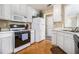 Bright kitchen featuring white cabinetry, modern appliances, and parquet flooring at 7008 Glen Valley Way, Fairburn, GA 30213