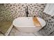 A freestanding tub sits against a mosaic tile wall, adding a touch of luxury to the modern bathroom at 2235 Birchtree Way, Marietta, GA 30062