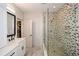 Elegant bathroom featuring a glass-enclosed shower with decorative tile and a white vanity with black hardware at 2235 Birchtree Way, Marietta, GA 30062