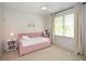 Cozy bedroom with a pink daybed, soft carpet, and a bright window, creating a warm and inviting space at 2235 Birchtree Way, Marietta, GA 30062
