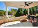 Covered patio with fan, brick columns, fire pit, and view of the wooded backyard at 2235 Birchtree Way, Marietta, GA 30062