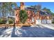 A brick home featuring a three-car garage and a covered porch nestled among mature trees at 5327 Saville Nw Dr, Acworth, GA 30101