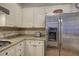 A detailed view of the kitchen showcasing granite countertops, white cabinets, stainless steel refrigerator, and a tile backsplash at 5327 Saville Nw Dr, Acworth, GA 30101