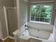 Bathroom featuring a garden tub, tile surround, shower with glass door and natural light at 5755 Belmont Ridge Cir, Lithonia, GA 30038