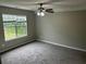 Carpeted bedroom featuring a ceiling fan, neutral walls, and natural light from a window at 5755 Belmont Ridge Cir, Lithonia, GA 30038