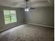 Large bedroom with a window, a ceiling fan, carpeted floor, and neutral walls at 5755 Belmont Ridge Cir, Lithonia, GA 30038