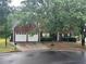 Traditional brick home with a two-car garage and a yard with mature trees at 5755 Belmont Ridge Cir, Lithonia, GA 30038