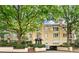 A tan three-story building featuring a brick entrance and trimmed by mature trees at 209 14Th Ne St # 109, Atlanta, GA 30309