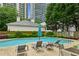 A refreshing pool with lounge chairs surrounded by lush greenery and high-rise buildings in the background at 209 14Th Ne St # 109, Atlanta, GA 30309