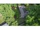 An aerial view of a home surrounded by lush trees, with a fenced garden, and visible roof detail at 23 Hunting Creek Dr, Marietta, GA 30068
