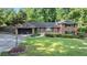 Charming brick home featuring a two-car garage and a lush, green front yard at 23 Hunting Creek Dr, Marietta, GA 30068