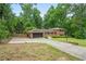 Charming brick home with a two-car garage and a spacious driveway with mature trees at 23 Hunting Creek Dr, Marietta, GA 30068