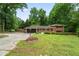 Traditional brick home with a well-manicured lawn, mature trees, an attached garage, and a classic red front door at 23 Hunting Creek Dr, Marietta, GA 30068