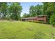 Classic brick home features an attached garage, well-kept lawn, and mature trees providing shade and curb appeal at 23 Hunting Creek Dr, Marietta, GA 30068