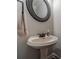 Half bath with a pedestal sink, designer faucet, and a decorative mirror at 2500 Morgan Chase Dr, Buford, GA 30519