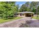 Charming single-story brick house featuring a covered driveway, lush trees, and a manicured lawn at 2575 Dobbs Nw Dr, Kennesaw, GA 30152