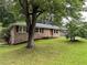 Charming brick home with mature tree, beautiful landscaping, and black shutters at 2575 Dobbs Nw Dr, Kennesaw, GA 30152