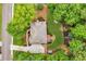 Aerial view of home and landscaped yard, including patio seating, mature trees and side driveway at 4020 Devereux Chase, Roswell, GA 30075