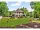 Sprawling backyard with a lush lawn, mature trees, and an outdoor living area with seating at 4020 Devereux Chase, Roswell, GA 30075