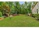 Expansive backyard with lush lawn, mature trees, a waterfall feature, and outdoor seating at 4020 Devereux Chase, Roswell, GA 30075