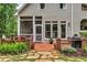 Exterior view of the home showcasing the backyard with brick patio, lush landscaping, and outdoor dining area at 4020 Devereux Chase, Roswell, GA 30075