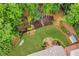 Aerial view of a beautifully landscaped backyard with waterfall, hammock, mature trees, and stone patio with outdoor furniture at 4020 Devereux Chase, Roswell, GA 30075