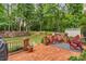 Expansive backyard featuring a brick patio, lawn, mature trees, and a variety of outdoor seating areas at 4020 Devereux Chase, Roswell, GA 30075