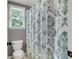 Bathroom with a decorative shower curtain, featuring a window that provides natural light at 4020 Devereux Chase, Roswell, GA 30075