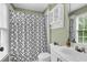 Bathroom featuring a decorative shower curtain, vanity with sink, and window providing natural light at 4020 Devereux Chase, Roswell, GA 30075