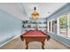 The basement billiards room has ample natural light and built-in shelving for decor at 4020 Devereux Chase, Roswell, GA 30075